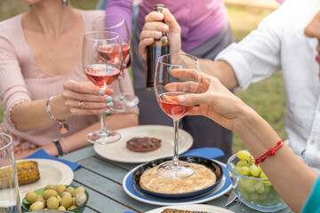 Close-up of a toast with red wine glasses. Beautiful colors hands and light.