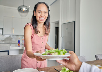 Obraz na płótnie Canvas Wife, healthy food and salad while serving lunch or supper for husband with a smile at home. Caring and happy housewife woman with a dinner plate and enjoying a vegan meal at the table together