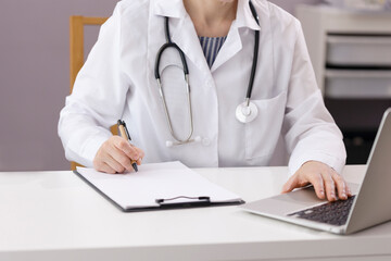 The doctor works in his office, sees patients and takes notes. The doctor works at the computer in the hospital. Medical photo with copy space. High quality photo
