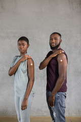 Obraz na płótnie Canvas African american man and woman standing showing arm after getting vaccination