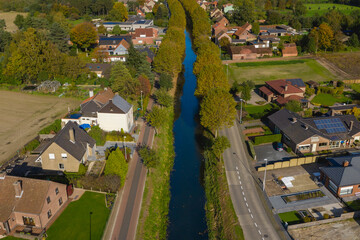 Fototapeta premium Aerial view of the Langelede canal crossing a residential area in Wachtebeke, Belgium