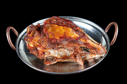 Roasting head of a lamb. Traditional Turkish Offal Food Kelle Sogus, Lamb Head Meat with Brain Served Portion served on a copper plate.