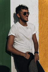 Hombre joven modelo con camisa blanca, gafas de sol y gorra