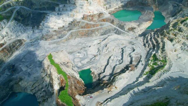 Aerial view flying over a quarry in the tropical, worker and many excavators are working. quarry industry. industrial concept. aerial drones footage. 4K
