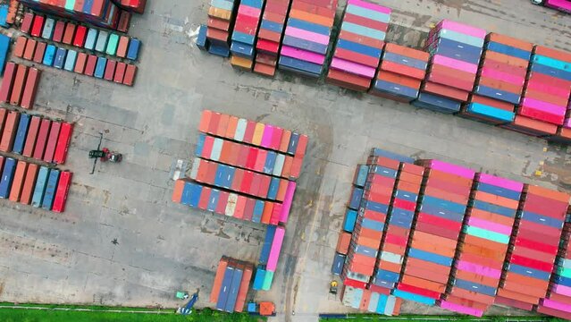 4K : Aerial view from a drone flying over a many cargo containers at distribution center. import and export industry. transportation concept
