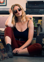 Fototapeta premium Grunge fashion, punk woman and rock hipster, retro model and confident female with glasses on floor. Portrait of young gen z, cool girl and attitude in creative style, urban fashion and trendy youth