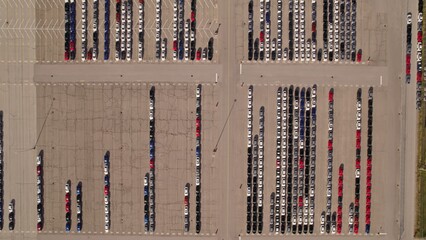 New hybrid EV cars stock parking. Aerial of parking lot of brand new cars for sale and transportation at manufacturer plant, automobile industry. Low carbon footprint electric vehicles from conveyor.