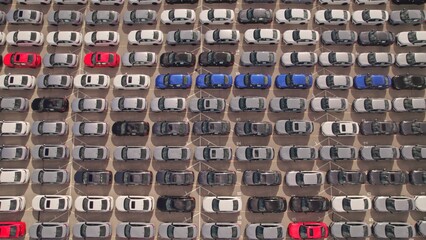 New cars located at the factory parking lot aerial view at golden hour. Car manufactory parking area for a new hybrid EV. High tech green electric vehicles sorted after industrial production conveyor. © desertsands