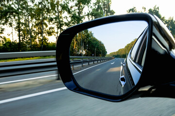 Fototapeta na wymiar Look in the rear view mirror of a car. Car driving on the road.
