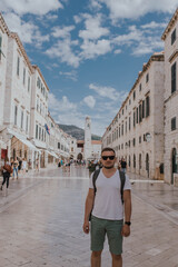 Obraz premium Dubrovnik, Croatia - September 21, 2021: Man tourist, traveler walks along Placa, the Main Street. Old town was listed as UNESCO World Heritage Sites in 1979 in Europe. primary promenade is Stradun