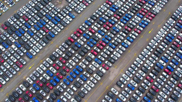 4K : Aerial view of the parked new cars in giant factory. automotive industry. drones footage
