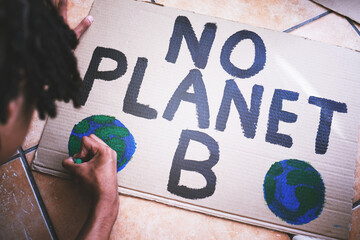 Environment, cardboard and poster for protest for climate change, global warming and earth day. Global, green and ecology with black man drawing a creative sign for environmental and energy crisis - obrazy, fototapety, plakaty