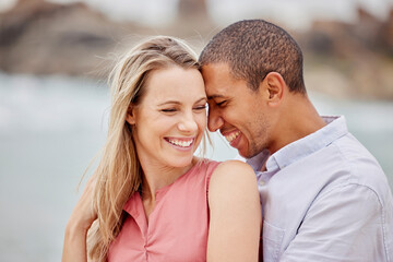 Fototapeta premium Love, happy and hug with couple together for romance, relationship and lifestyle on beach holiday trip. Happiness, care and support with man and woman in embrace on summer vacation date by the sea