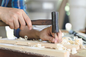 worker using a hammer in woodwork construction