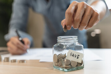 the person putting coin into piggy bank to save money and invest for growth in future.