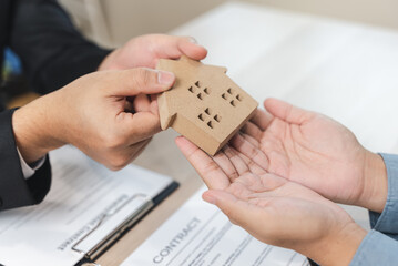 Realtor agent giving a key of apartment to new owner after signed lease agreement.