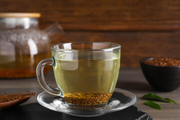 Freshly made buckwheat tea in glass cup on wooden table, closeup