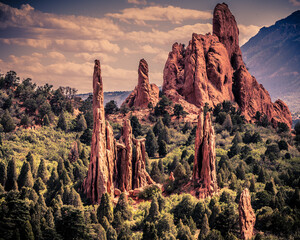 Surreal  rock pinnacles with red rock sand stone towers surrounded by scrub oak, pine trees and...