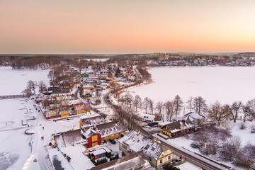 Aerial view of Trakai town, known for Trakai Island Castle. Snow covered frozen Galve lake on sunny winter sunrise.