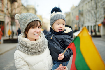 Beautiful teenage girl and her adorable toddler brother celebrating Lithuanian Independence Day.