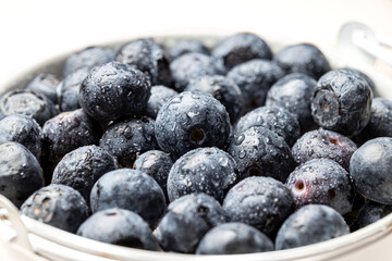 Macro photo of Bucket or bowl full of fresh blueberries on white background