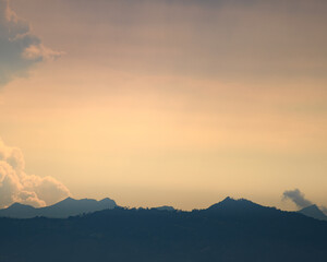 Obraz premium Yellow and blue Sunset landscape with light clouds. Atarcdecer azul y amarillo con leves nubes.