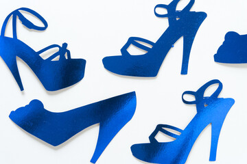 blue paper silhouette of stiletto shoes on a white background 