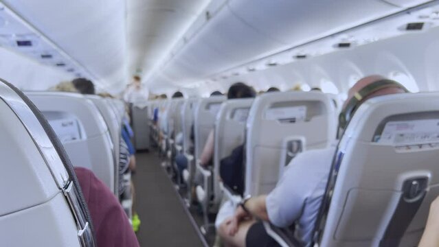 Blurred background of air hostess giving service to flight passengers by serving food and drink from carrier tray shows concept of tourist travelling transportation for holiday vacation.