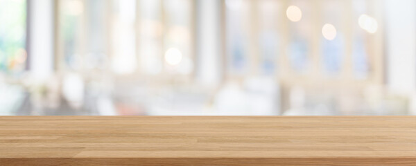 Empty wood table top and blurred coffee shop, cafe and restaurant interior background - can used...