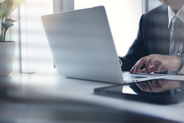 Asian business man working on laptop computer at modern office. Businessman in black suit working...