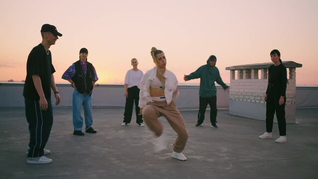beautiful cool girl is dancing twerk and dancehall on roof, moving energetically, youth dance party