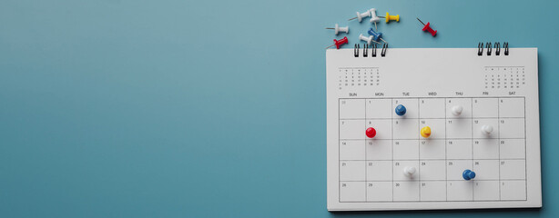 Embroidered red pins on a calendar event Planner calendar,clock to set timetable organize schedule,planning for business meeting or travel planning concept. © kunakorn