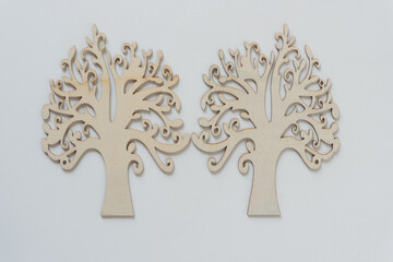 two ornate wooden tree silhouettes arranged in mirror form