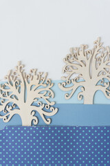 two ornate wooden tree silhouettes tucked inside a winter landscape