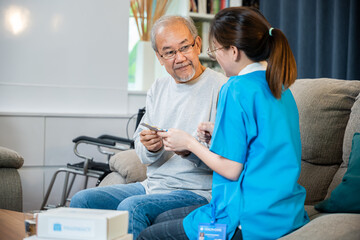 Obraz premium Asian nurse with physician explaining prescription medicine to attentive senior man at home, Doctor woman explain dosage pill old man, Healthcare worker caregiver visiting in house in living room