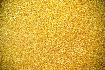 Gold colour paint wall background bright texture with uneven patterns
