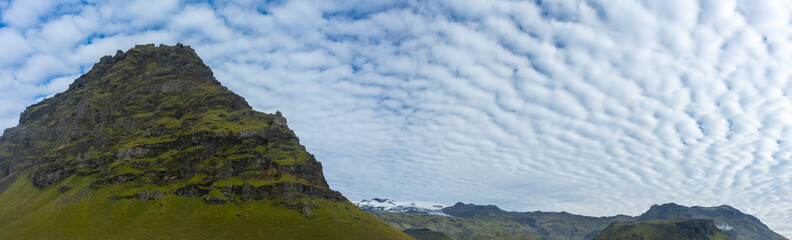 mountain with fluffy clouds and dormant volcano Eyjafjallajökull in the background