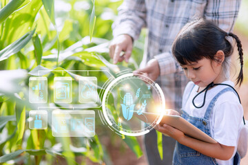 The little girl uses a tablet to analyze the growth of plants in the agricultural plot and visual...