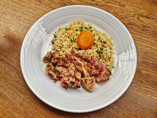Fried Rice with Medium Rare Beef Steak and Egg on Wooden Table
