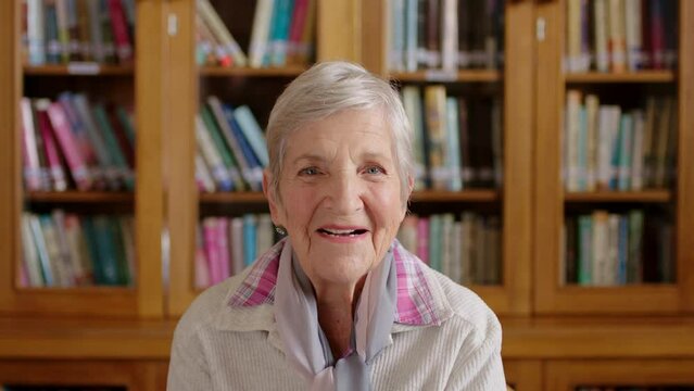 Happy elderly woman, laugh in library or bookstore with closet of books in the background. Senior lady with expression of happiness on face, react to comic moment or joke in information center.