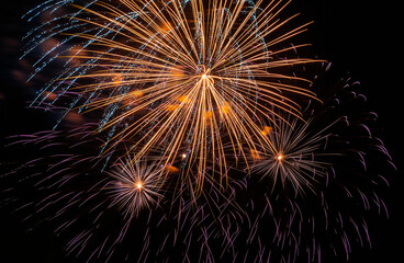 Obraz premium Festive fireworks. Bright rays from explosion of pyrotechnics, New Year's fireworks against black night sky.