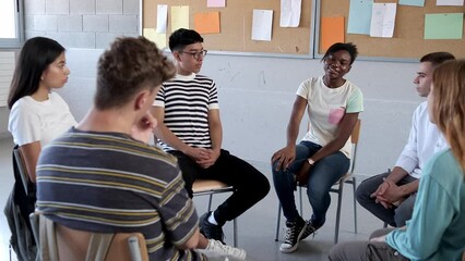 Teen black female talking about struggles in group therapy. Teen hispanic boy showing support. Mental health. 4k video.