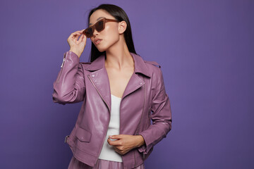 Fashion asian female model. Lilac leather jacket, lilac skirt