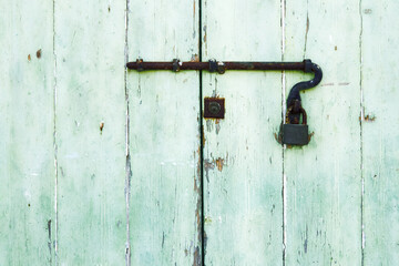 Schloss und Riegel rostig an einer alten hellen Holztür, Teilaufnahme, horizontal 