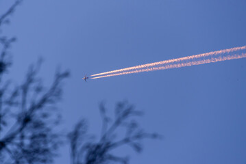airplane in the sky with strong contrails