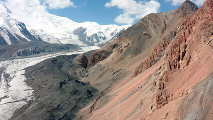 Colorful mountains, snow-capped peaks and glaciers under Lenin Peak. Panorama of an amazing mountain landscape.