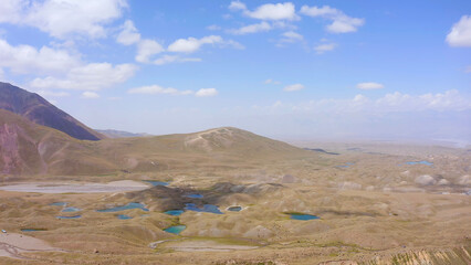 Aerial view of the green valley with blue mountain lakes under Lenin Peak. Beautiful nature of Kyrgyzstan.