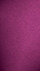 Dark pink colored paper texture. Tinted vertical background with vignetting. Textured mobile phone wallpaper. Large patterned surface. Fibers and irregularities are visible. Top-down
