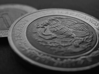Coin of 5 five Mexican pesos closeup. Peso of Mexico. Reverse of coin with coat of arms of country. Eagle and snake. Black and white background. News about economy or banking. Credit and money. Macro