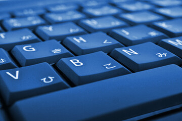Japanese typing. Light blue laptop keyboard. Symbols on the buttons of hiragana. Electronic...